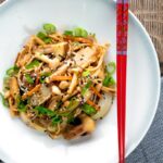 Overhead vegetarian mushroom chow mein noodles served in a white bowl.