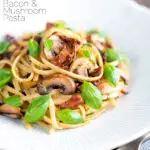 Bacon and mushroom pasta with sun dried tomatoes featuring a title overlay.