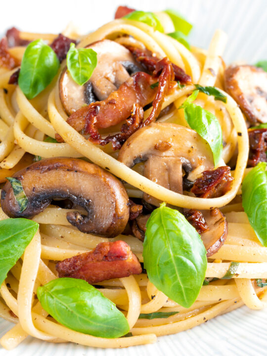 Close up bacon and mushroom pasta with sun dried tomatoes.