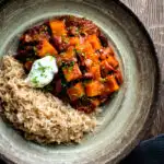 Overhead butternut squash chilli served with brown rice, and sour cream.