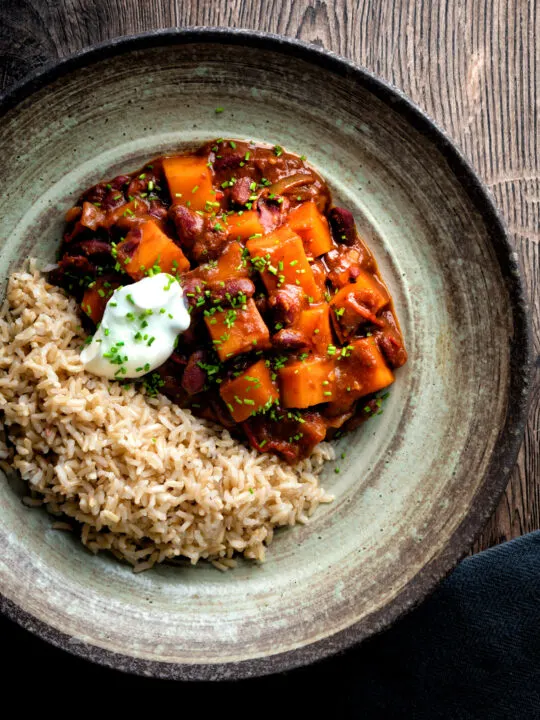 Overhead butternut squash chilli served with brown rice, and sour cream.