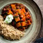 Overhead butternut squash chilli served with brown rice, and sour cream featuring a title overlay.