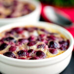 Individual cherry clafoutis desserts served in brulée pots.