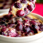 Spoon taken from an individual cherry clafoutis dessert.