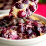Spoon taken from an individual cherry clafoutis dessert.
