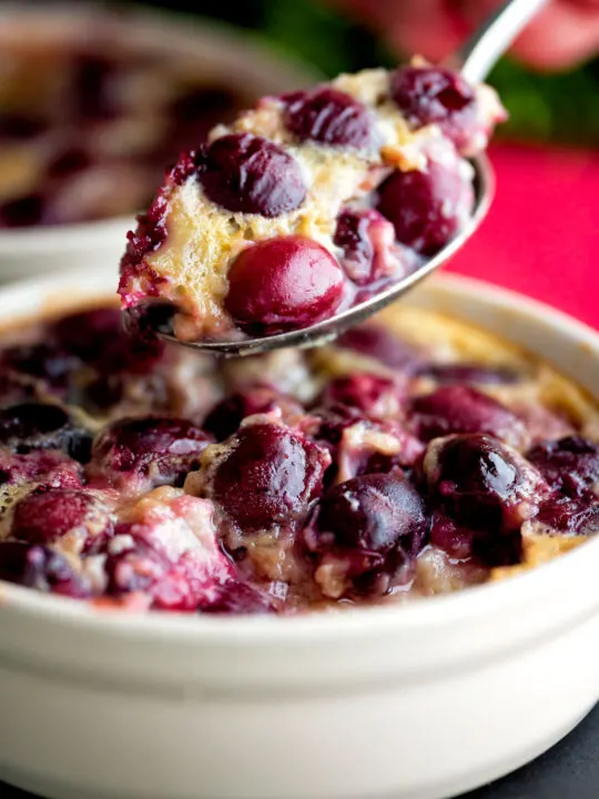 Spoon taken from an individual cherry clafoutis dessert.