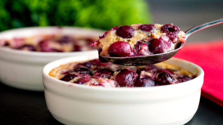 Spoonful taken from an individual cherry clafoutis dessert.