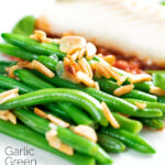 Garlic green beans served on a white plate garnished with almonds featuring a title overlay.