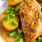 Close up garlic lemon chicken breast served with potatoes and broad beans featuring a title overlay.