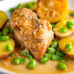 Garlic lemon chicken breast served with potatoes and broad beans.