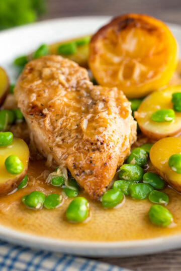 Garlic lemon chicken breast served with potatoes and broad beans.