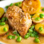 Garlic lemon chicken breast served with potatoes and broad beans featuring a title overlay.