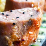 Close up honey and miso glazed pork tenderloin with sesame seeds.