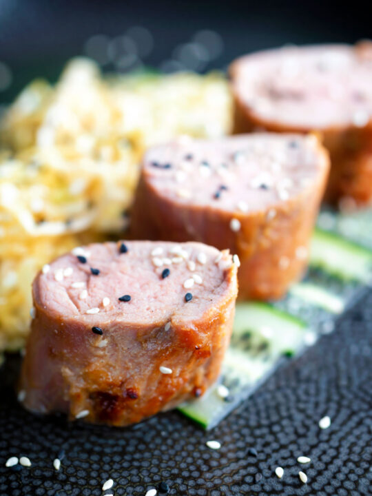 Honey and miso glazed pork tenderloin with sesame seeds.