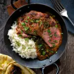 Overhead image of an Indian duck breast curry served with rice and naan bread featuring a title overlay.