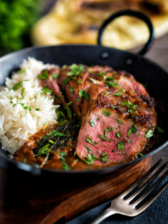 Indian duck breast curry served with rice and naan bread.