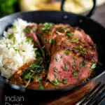 Indian duck breast curry served with rice and naan bread featuring a title overlay.