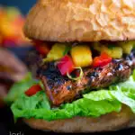 Jamaican jerk chicken burger with a mango salsa and crispy lettuce featuring a title overlay.