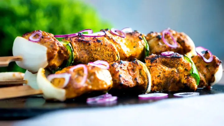 Lamb tikka kebabs with onion and green pepper served with red onion.