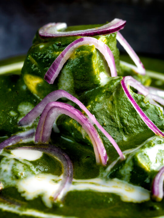 Close up Indian palak paneer spinach curry served with naan bread.