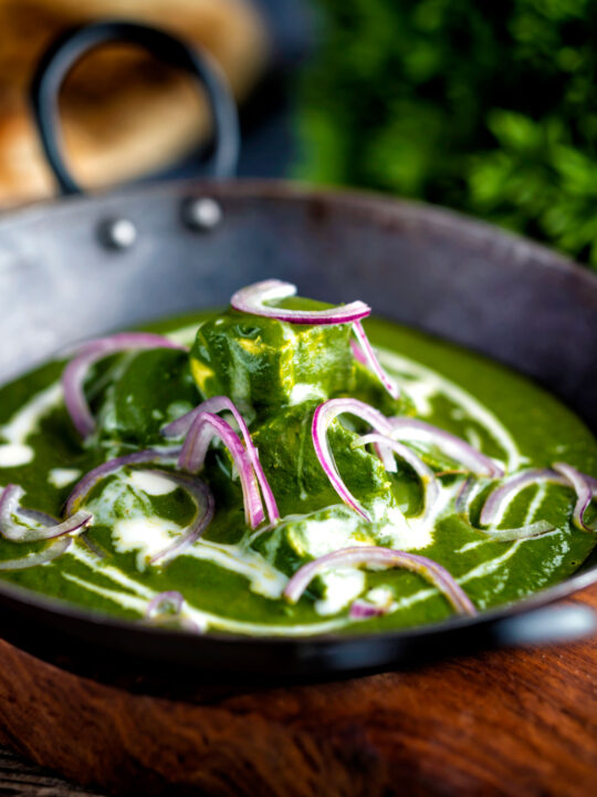 Indian palak paneer spinach curry served with naan bread.