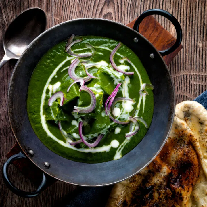 Indian palak paneer spinach curry served with poppy seed naan bread.
