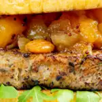 Closeup ork and apple burgers served with rocket, chutney featuring a title overlay.
