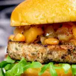 Pork and apple burgers served with rocket and apple chutney featuring a title overlay.