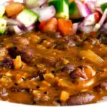 Close up rajma masala kidney bean curry served with kachumber salad featuring a title overlay.