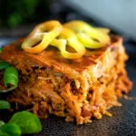Rakott kaposzta, Hungarian sauerkraut casserole served on a black plate.