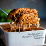 Steaming hot rakott kaposzta, Hungarian sauerkraut casserole being removed from a bowl featuring a title overlay.