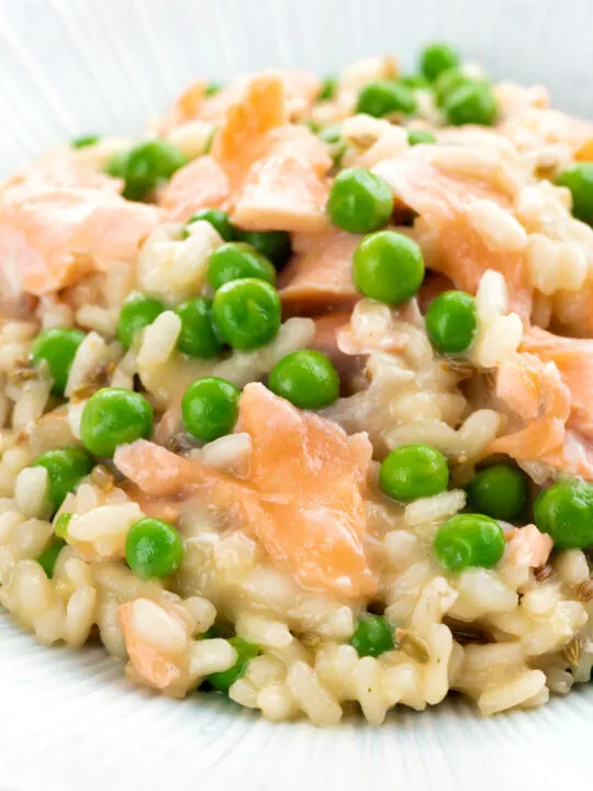 Close up salmon risotto with green peas and fennel seeds.