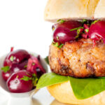 Shredded duck burgers topped with cherry salsa on a burger bun featuring a title overlay.