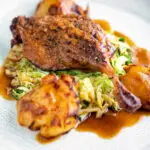 Slow roast duck leg with balsamic gravy, cabbage and roast potatoes.