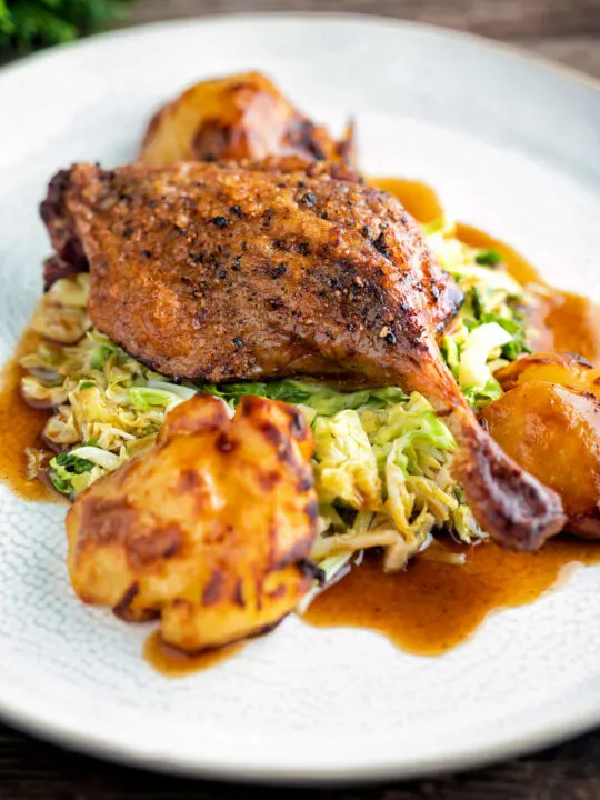 Slow roast duck leg with balsamic gravy, cabbage and roast potatoes.