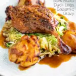 Slow roast duck leg with balsamic gravy, cabbage and roast potatoes featuring a title overlay.