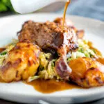 Balsamic gravy being poured over a slow roast duck leg.