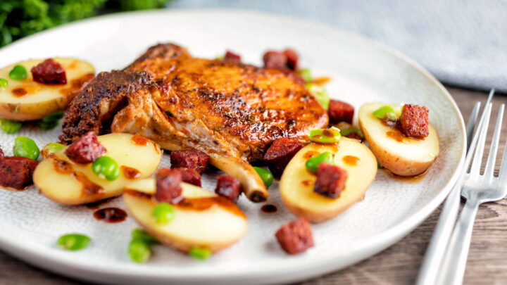 Spanish pork chop with chorizo sausage, broad beans and potatoes with paprika oil.