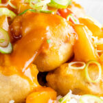 Close up crispy sweet and sour pork balls served with rice.