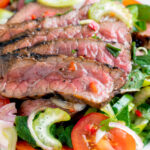 Close up Thai beef salad with rare beef, tomatoes, mint, chilli and cucumber.