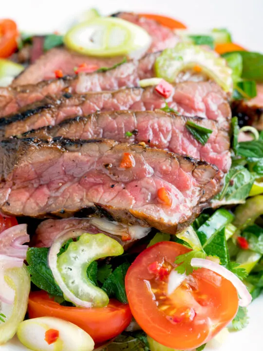 Close up Thai beef salad with rare beef, tomatoes, mint, chilli and cucumber.
