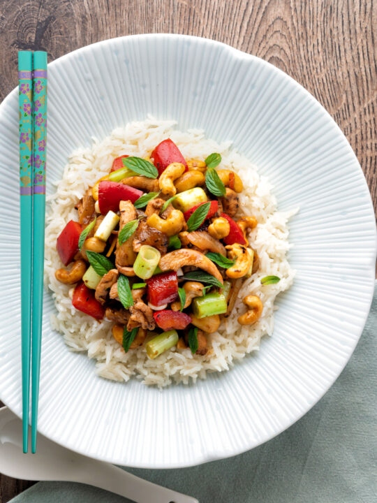 Overhead Thai cashew chicken stir fry served on steamed rice.