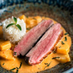 Thai red duck curry with pineapple, rice and Thai basil featuring a title overlay.
