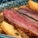 Close up Thai red duck curry with pineapple, rice and Thai basil.