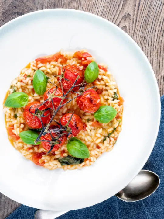 Overhead tomato risotto with basil and roasted tomatoes.