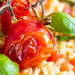 Close up tomato risotto with basil and roasted tomatoes.