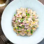 Overhead tuna pasta salad with peas, corn and red oniion.