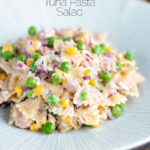 Tuna pasta salad with peas, corn and red onion featuring a title overlay.