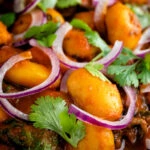 Close up Indian butter bean curry served with coriander and red onion.