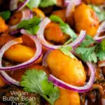 Close up Indian butter bean curry served with a naan bread featuring a title overlay.